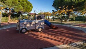 Un terrain de jeux avec un toboggan et une petite structure ressemblant à un véhicule.