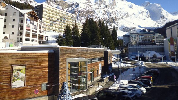 A hotel with a modern design, featuring a wooden facade and large windows. It is located in a snowy mountainous area with a view of snow-covered peaks in the background. - Studio cabin 4 people at slope base in Gourette (Gourette)