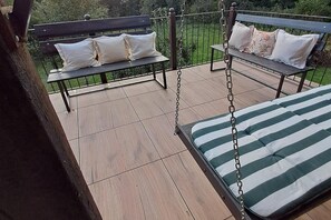 A patio with two wooden benches and a swing. - Half of a holiday home, large garden, terrace (Szymbark)