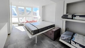 Une chambre à coucher moderne avec un lit, un banc et un lit superposé.