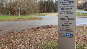 Ein Schild für das Ansager Hotel mit Kontaktinformationen und einem QR-Code für soziale Medien.