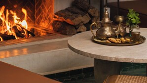 A fireplace with a fire, a tray with tea and snacks, and a lantern. - Riad Mint  (Marrakech)