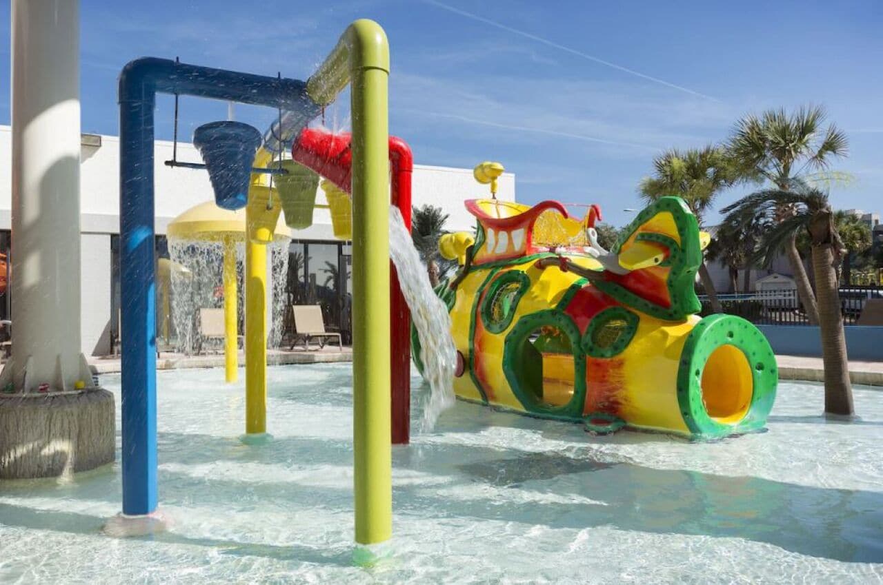 A water park with a colorful play structure and a pool.