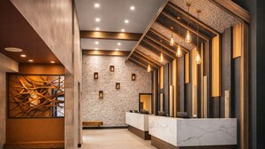 Een receptie met een marmeren balie, houten details en een bakstenen muur.