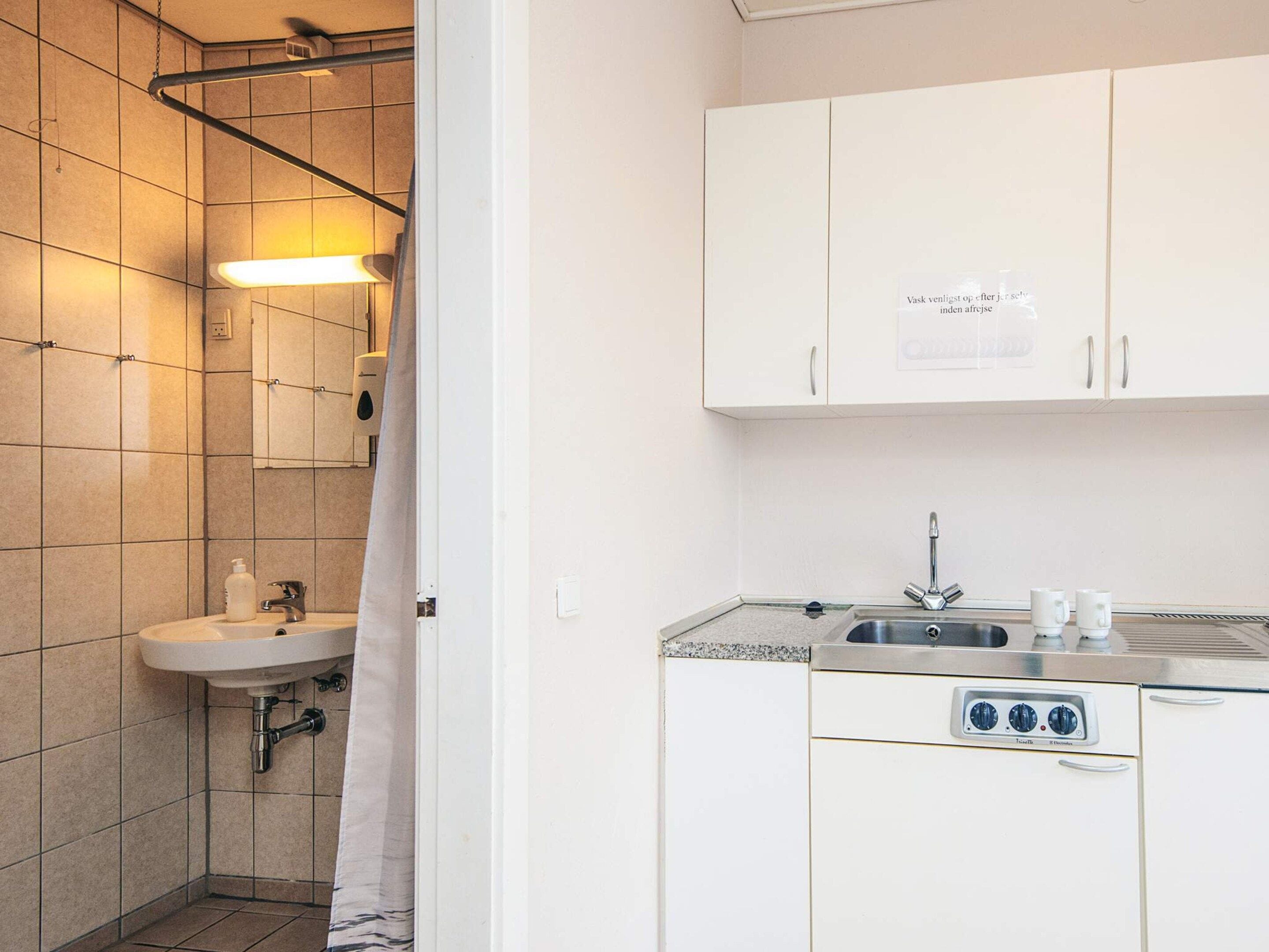 Un baño moderno con lavamanos, espejo y toallero.