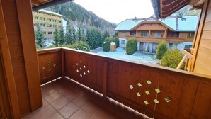 Ein Holzbalkon mit Blick auf einen Berg und Gebäude.