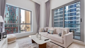 Ein modernes Wohnzimmer mit einem weißen Sofa, einem Marmortisch und großen Fenstern mit Blick auf die Stadt.