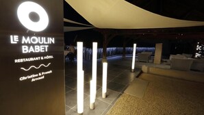 Een terras met verlichte palen en een overkapping.
