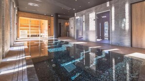 A spacious lobby with a reflective water feature and a wooden reception area. - Apartment With Mont Blanc View & Spa (Combloux)