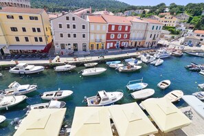 Ein Yachthafen mit vertäuten Booten, eine Uferpromenade und farbenfrohe Gebäude.