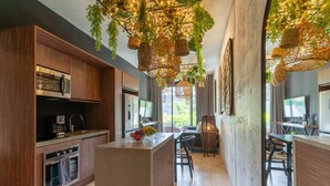 Una cocina moderna con armarios de madera, una isla central y lámparas colgantes de mimbre.