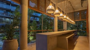 Ein modernes Interieur mit einer langen Bank, großen Fenstern und hängenden Lampen.