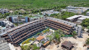 Un hôtel moderne doté d’une cour intérieure, de nombreux balcons et offrant une vue sur l’océan.