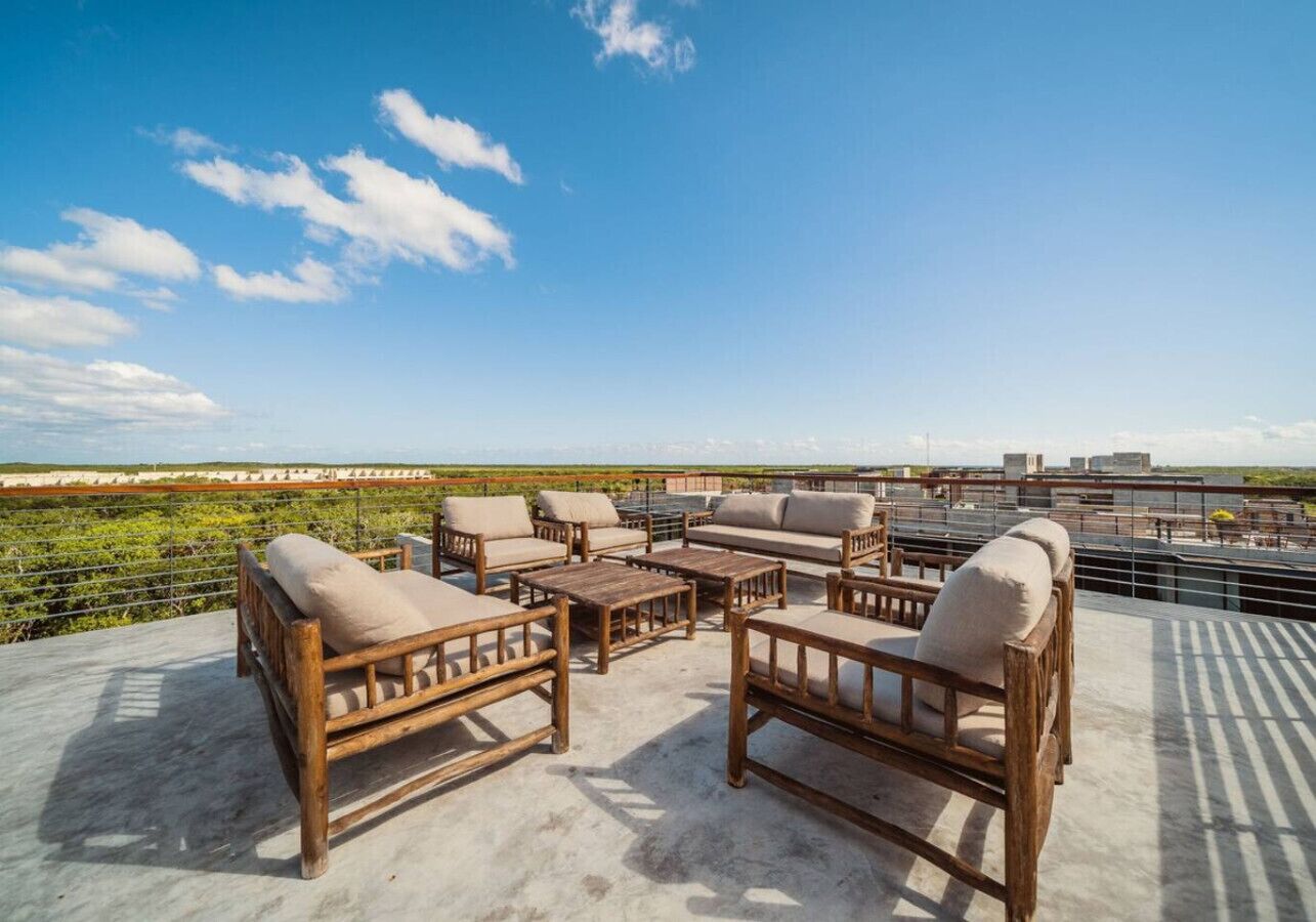 Eine Dachterrasse mit Holzmöbeln und Blick auf den darunterliegenden Weinberg.