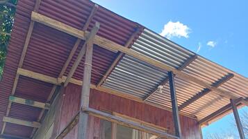 A wooden structure with a balcony and a corrugated metal roof.