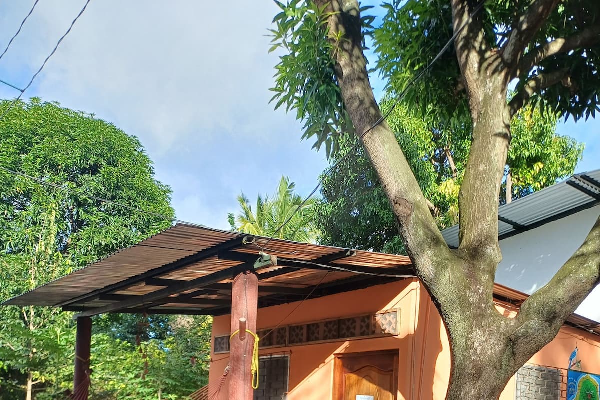 Una casa con veranda, un'amaca, una porta e una finestra.