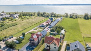 Un quartier résidentiel avec des maisons, une route et une étendue d’eau en arrière-plan.