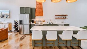 Een moderne keuken met een centraal eiland, een bar en hanglampen.