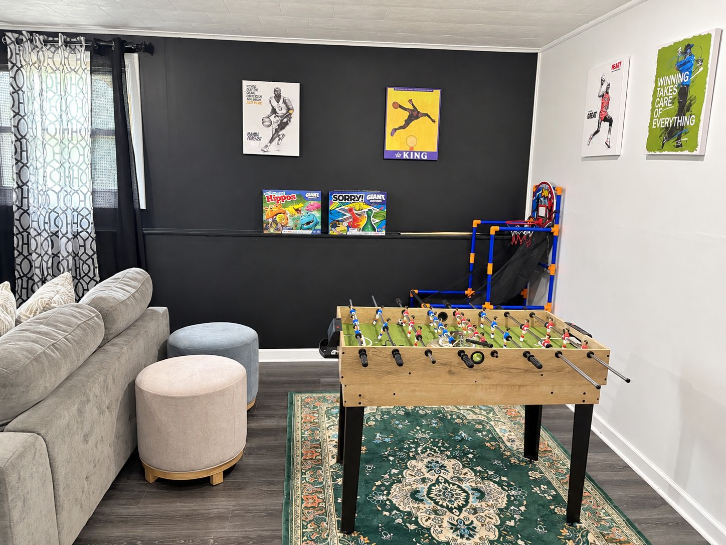 Ein Wohnzimmer mit einer Couch, einem Hocker und einem Kicker.
