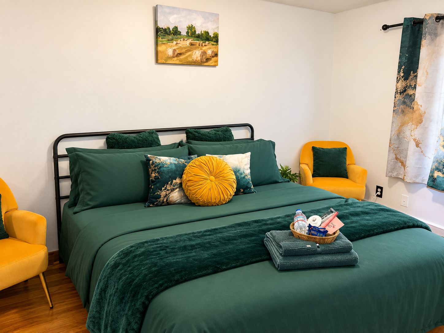 Une chambre à coucher avec un lit, deux chaises, un tableau au mur et un rideau.