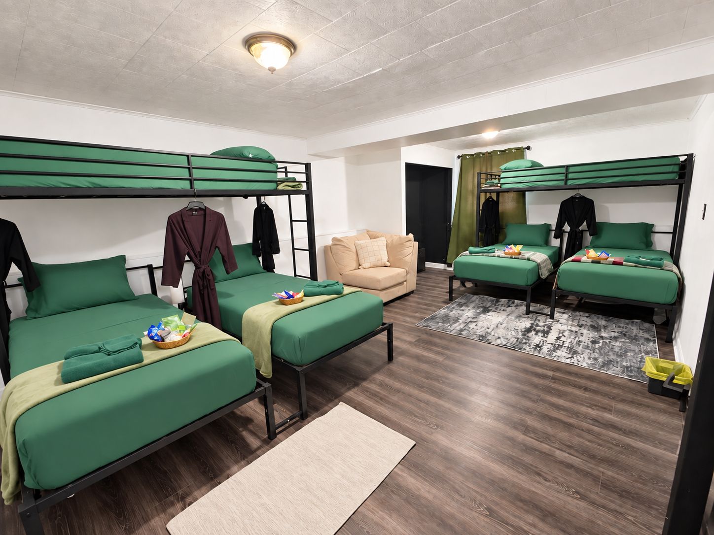 Ein Schlafsaalzimmer mit Etagenbetten, einer Schlafcouch und einem kleinen Tisch mit Gegenständen darauf.