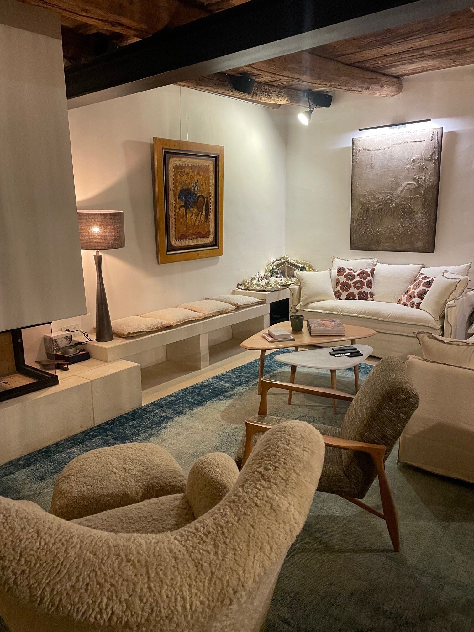 A cozy living room with a sofa, armchairs, a coffee table, and a rug.