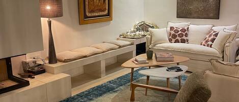 A cozy living room with a sofa, armchairs, a coffee table, and a rug.