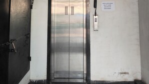 An elevator in a hotel lobby with a sign above stating "HOTEL LOTUS GOLD 2nd FLOOR 9041282665". - HOTEL LOTUS GOLD (Vadodara)