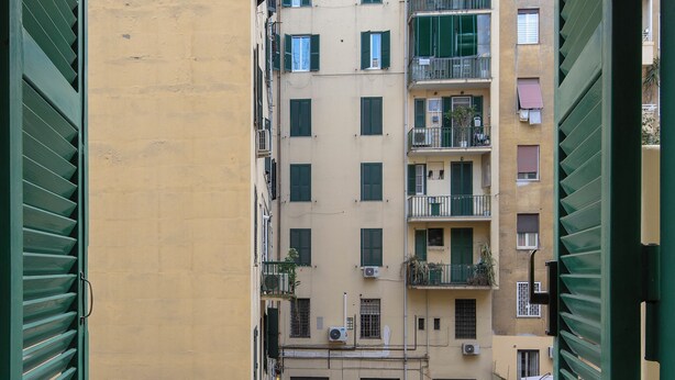 A view from a balcony with a beige wall and green shutters, overlooking a multi-story building with balconies and windows. - 3-minute walk from Metro Line B, P. Bologna, Tiburtina Station (Airport Link), 2 bedrooms, 2 bathrooms, A/C, Wi-Fi (Roma)