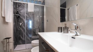 A modern bathroom with a glass-enclosed shower, a white sink, and a large mirror. - 3-minute walk from Metro Line B, P. Bologna, Tiburtina Station (Airport Link), 2 bedrooms, 2 bathrooms, A/C, Wi-Fi (Roma)