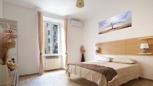 A bedroom with a bed, a window, a radiator, and a painting on the wall. - 3-minute walk from Metro Line B, P. Bologna, Tiburtina Station (Airport Link), 2 bedrooms, 2 bathrooms, A/C, Wi-Fi (Roma)