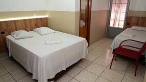 A hotel room with two beds, a red chair, and a door leading to a bathroom. - Hotel Vitória Régia (Engenheiro Beltrão)