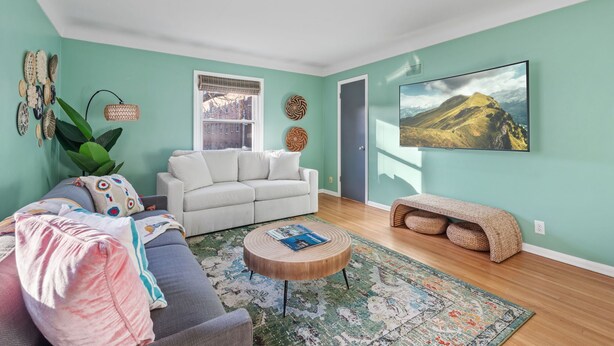 Ein Wohnzimmer mit einer Couch, einem Couchtisch, einem Fernseher und einer Tür.