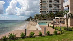 Ein Strandhotel mit Pool, Palmen und Blick aufs Meer.