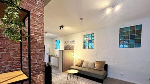 Un salon moderne avec un canapé, une petite table et une plante décorative.