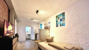 Un salon moderne avec un canapé, un téléviseur et une cheminée.