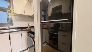 Cocina compacta con lavadora, refrigerador y microondas.
