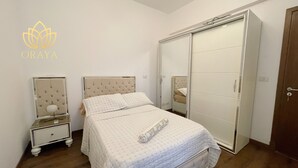 Un dormitorio con cama, mesita de noche, armario y espejo.