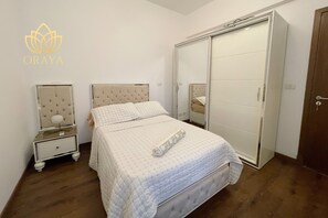 Ein Schlafzimmer mit Bett, Nachttisch, Kleiderschrank und Spiegel.