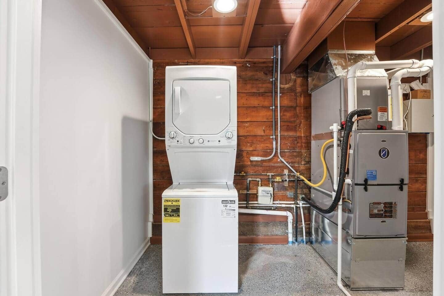 Un cuarto de servicio compacto con calentador de agua, bomba de agua y caldera.