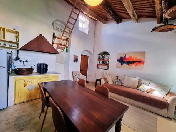 A compact living space with a kitchen, dining area, and a sofa. - Casa Bella in Central Noto, a Unique Sicilian Stay (Noto)