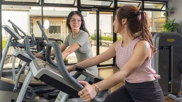 A gym with stationary bikes and a treadmill.