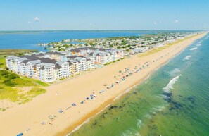 Ein Küstenhotel mit mehreren Gebäuden, einem Sandstrand und Blick auf den Ozean.