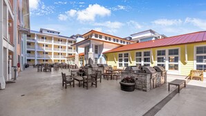 Une cour avec des espaces de détente en plein air, un coin barbecue et une piscine.