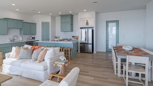 Una cocina moderna con armarios color turquesa, una isla central y un refrigerador de acero inoxidable.