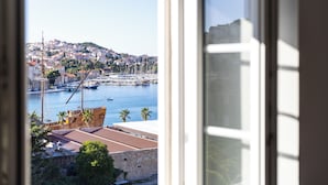 Un paisaje urbano costero con vista a un puerto, edificios y un barco.
