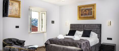 Un dormitorio moderno con una cama grande, una silla y un ventanal.