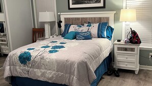 A bedroom with a bed, a nightstand, a lamp, a chair, a ceiling fan, and a framed picture on the wall. - 2-bedroom 2bath mobile home in lovely Alligator Park Punta Gorda FL with AC (Punta Gorda)