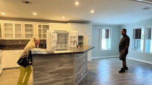 A modern kitchen with white cabinets, a wooden countertop, and a built-in refrigerator. - 2-bedroom 2bath mobile home in lovely Alligator Park Punta Gorda FL with AC (Punta Gorda)