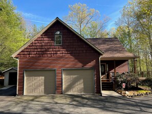 A two-story red wooden house with a garage, a covered porch, and a small window. - Hidden Haven - mountain retreat in Fleetwood, NC (Fleetwood)